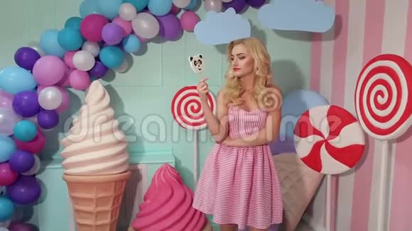 芭比娃娃女孩穿着粉红色连衣裙和糖果的肖像视频的预览图