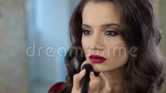 化妆师在沙龙为女孩化妆视频的预览图