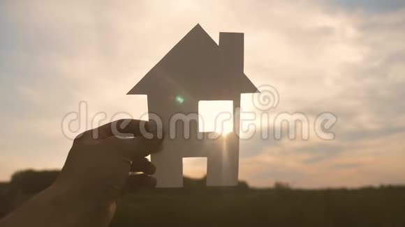 幸福家庭建房理念生活方式一个人手里拿着一个纸房手里拿着夕阳的剪影视频的预览图
