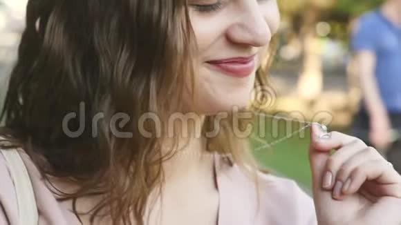 户外一位美丽微笑的年轻女子的肖像慢动作视频的预览图
