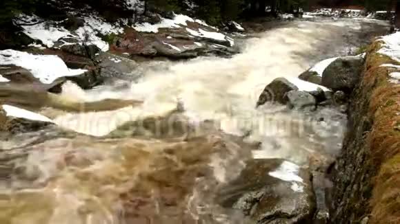 快速流动山河满园寒泉水倾斜的大石头和泡沫的冷水周围巨大的水的噪音视频的预览图
