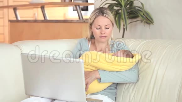 女人抱着孩子用笔记本电脑视频的预览图