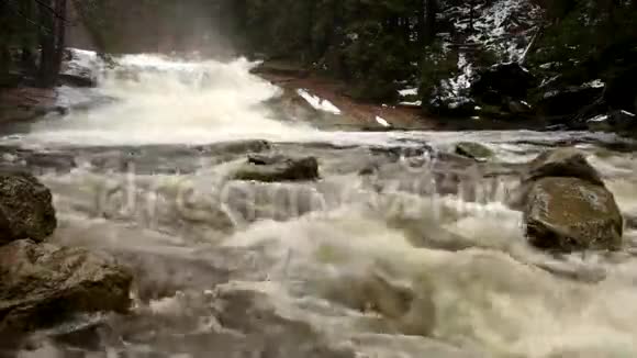 快速流动山河满园寒泉水倾斜的大石头和泡沫的冷水周围巨大的水的噪音视频的预览图