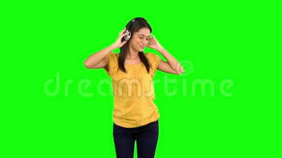 戴着耳机在绿色屏幕上跳舞的女人视频的预览图