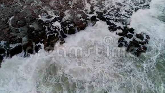岩石海岸线的鸟瞰与海浪撞击视频的预览图