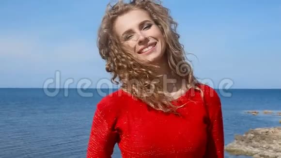 特写一幅女子手挽卷发在沙滩上海风中奔跑的肖像蓝天上快乐的女性视频的预览图