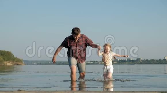 爸爸和女儿一起玩耍的特写镜头一位年轻的父亲正在海边给他的女儿纺纱视频的预览图
