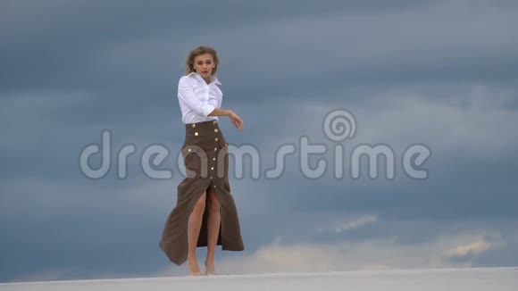 美丽的女人在沙漠中的沙滩上行走视频的预览图