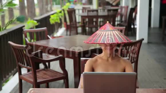 带手提电脑和电话的咖啡馆里的亚洲自由职业女性视频的预览图