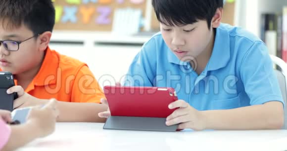 亚洲孩子一起玩平板电脑视频的预览图