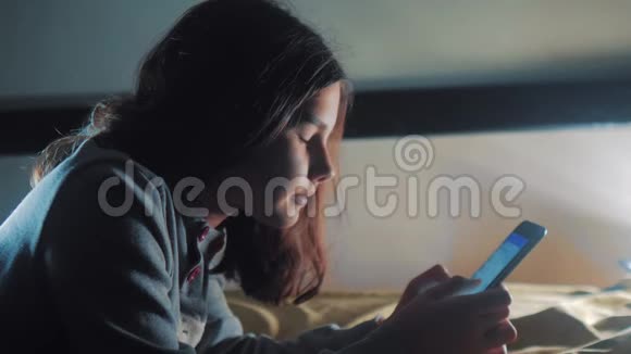 少女和智能手机小青少年帽女孩在社交媒体信使之夜的聊天生活方式中写信息视频的预览图