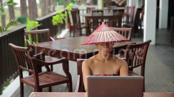 带手提电脑和电话的咖啡馆里的亚洲自由职业女性视频的预览图