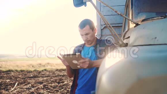 智慧农业男子农民司机站在卡车附近的数字平板电脑慢动作生活方式视频肖像视频的预览图