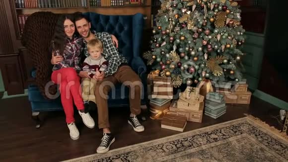 幸福的家庭和一个孩子在圣诞树附近视频的预览图