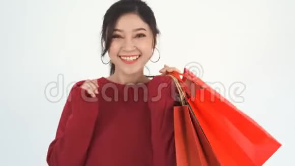 女人拿着红色的购物袋视频的预览图