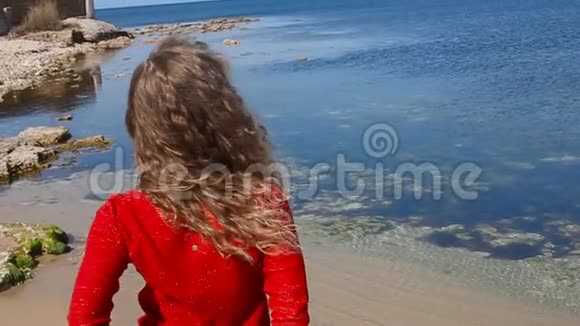 特写一幅女子手挽卷发在沙滩上海风中奔跑的肖像快乐的女人越过蓝天视频的预览图