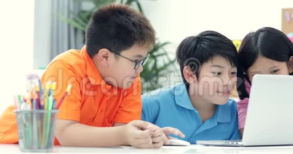可爱的亚洲孩子一起使用笔记本电脑视频的预览图