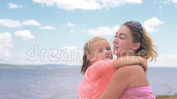 小可爱的女孩和海滩上的年轻母亲视频的预览图