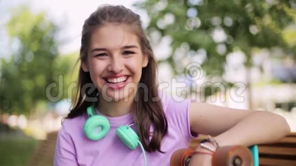 带着耳机和长板的快乐少女视频的预览图