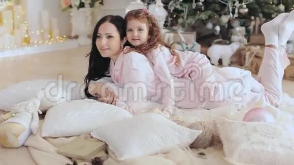 母亲和女儿穿着睡衣在圣诞树附近视频的预览图