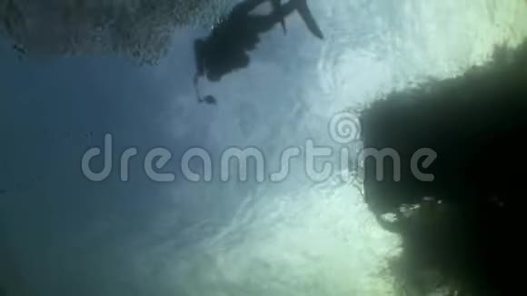 水下反射阳光背景下的潜水员剪影视频的预览图