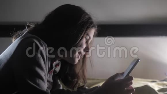 少女和智能手机小生活方式少女风帽女孩在社交媒体信使之夜留言聊天视频的预览图