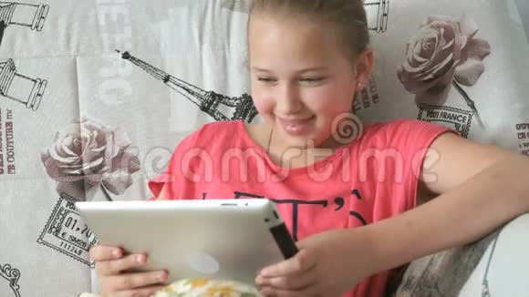躺在床上的小女孩拿着数码平板电脑视频的预览图