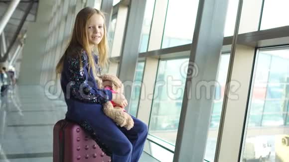 可爱的小女孩带着行李在机场等待登机视频的预览图
