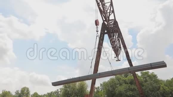 龙门吊从货车上卸下型材管道在仓库装载金属大型龙门吊视频的预览图
