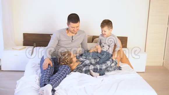 爸爸妈妈和儿子早上躺在家里的床上视频的预览图