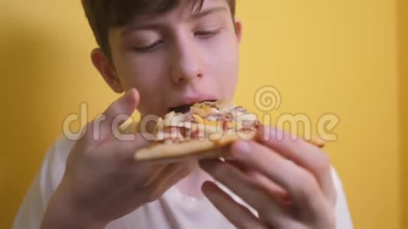 快乐的小男孩吃一片披萨的概念小男孩饿了吃一片披萨慢动作录像匹萨快视频的预览图