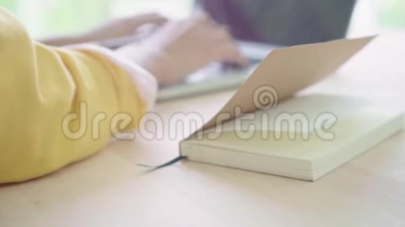 美丽的年轻微笑的亚洲女人在家客厅的桌子上工作笔记本电脑视频的预览图