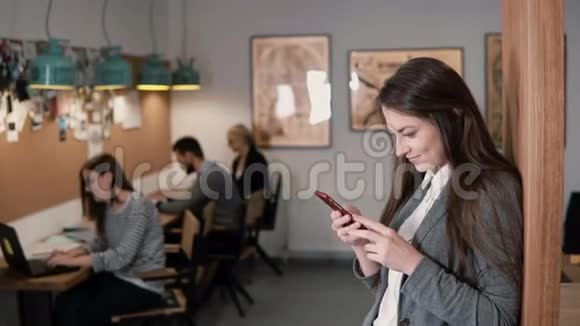 年轻漂亮的黑发女商人在现代的创业办公室里使用触摸屏平板电脑视频的预览图