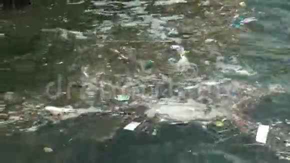 垃圾和漂浮在水面上的垃圾漂浮在海洋上的肮脏塑料垃圾造成的水污染视频的预览图