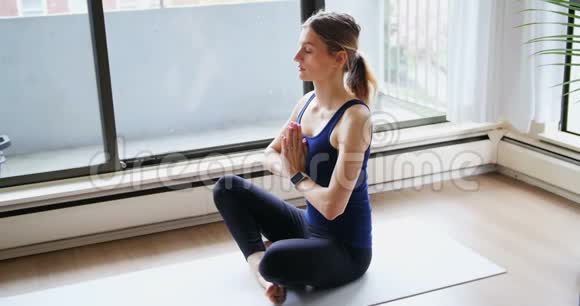 女人在家里做瑜伽视频的预览图