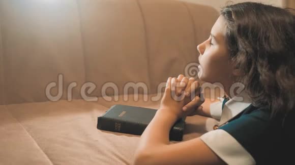 小女孩在夜里祈祷小女孩用手祈祷小女孩圣经在她的生活方式中祈祷圣经视频的预览图