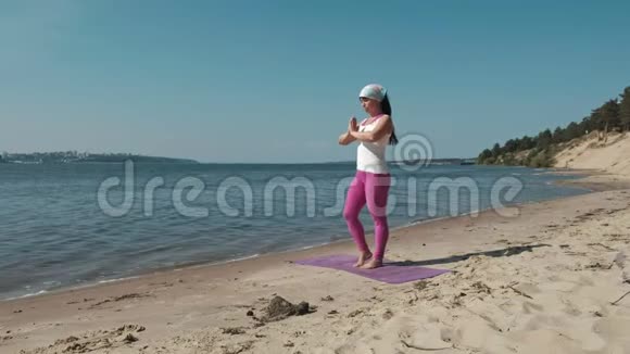 退休老妇人在海滩上做瑜伽视频的预览图