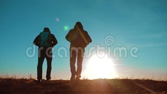 团队合作两名游客徒步旅行男人和狗带着背包在日落时散步去徒步旅行慢动作录像旅程视频的预览图