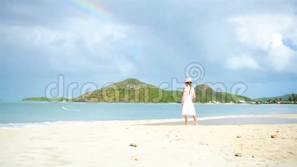 加勒比海度假期间海滩上戴帽子的可爱小女孩视频的预览图