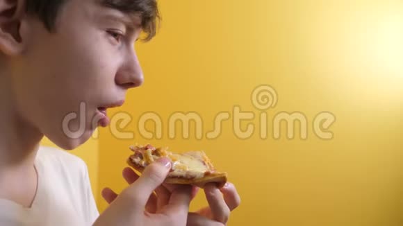 披萨快乐的青少年男孩吃一片披萨的概念十几岁的男孩饿了吃一片比萨饼慢动作视频的预览图