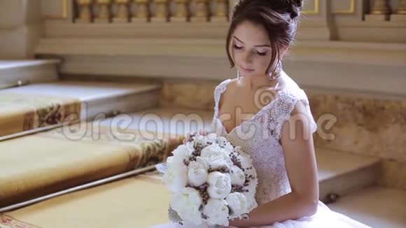 新娘穿着新娘礼服带着花束和蕾丝面纱视频的预览图