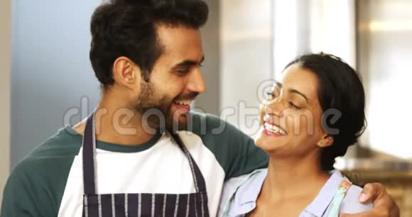 幸福的一对夫妻站在厨房里视频的预览图