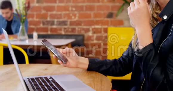 4k桌上的漂亮女人用手机和笔记本电脑视频的预览图