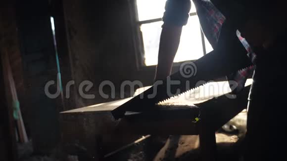 匠心手工与工艺概念慢动作视频木匠在车间里锯树的生活方式锯阳光视频的预览图