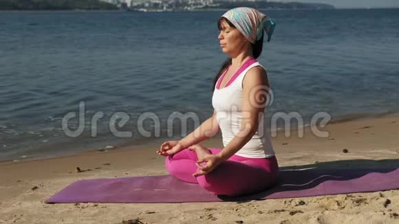 退休老女人在海滩上做瑜伽超级慢动作视频的预览图