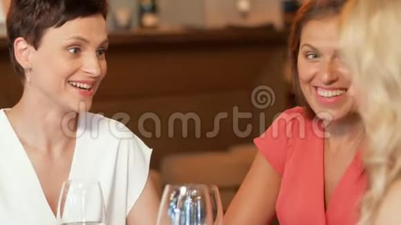 在酒吧或餐馆喝酒的快乐女人视频的预览图