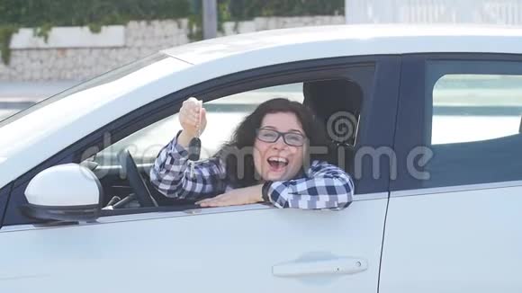 年轻快乐的白种人女人展示新车的关键视频的预览图