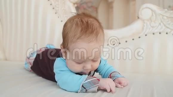 可爱的婴儿躺在白色的床上视频的预览图