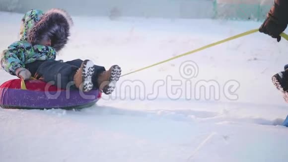 一个快乐的孩子在雪管里骑着雪慢动作冬天的雪景户外运动视频的预览图