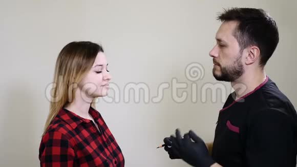 男性美容师戴黑色手套在女性眉毛上做永久化妆程序美容师美容师视频的预览图